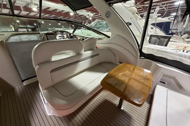 Slide: The Image of 2005 Sea Ray 360 Sundancer interior with plush seating and wooden table. - 28