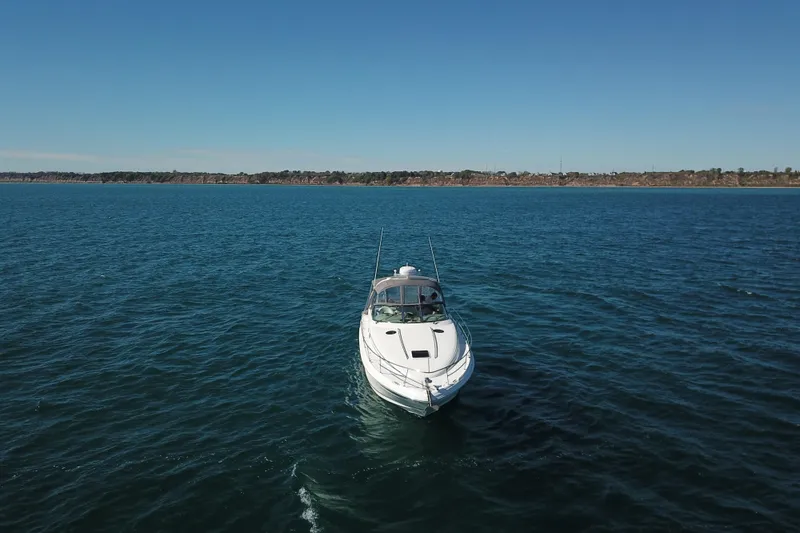 Slide: The Image of 2005 Sea Ray 360 Sundancer cruising on open water under clear blue sky. - 3