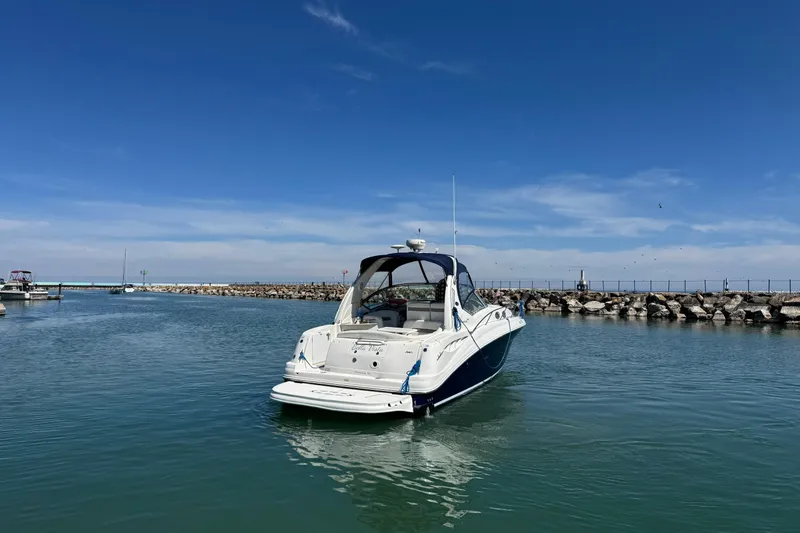 Slide: The Image of 2004 Sea Ray Sundancer 320 yacht in a serene harbor setting. - 10