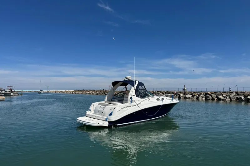 Slide: The Image of 2004 Sea Ray Sundancer 320 yacht cruising in a calm marina under a clear blue sky. - 11