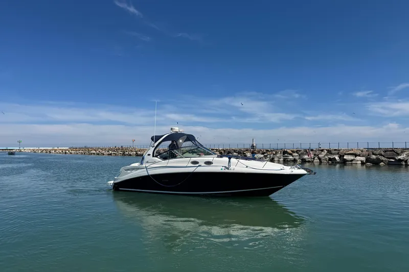 Slide: The Image of 2004 Sea Ray Sundancer 320 yacht cruising in a calm harbor under a clear blue sky. - 15