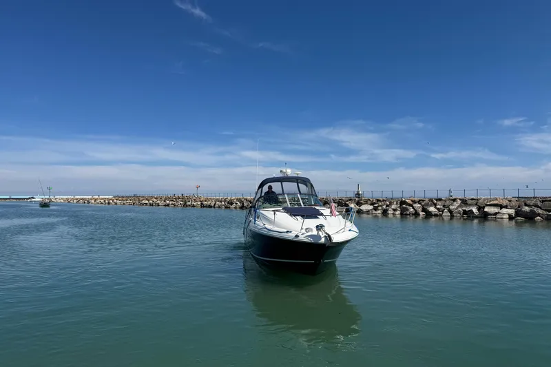 Slide: The Image of 2004 Sea Ray Sundancer 320 cruising in a calm harbor under a clear blue sky. - 19