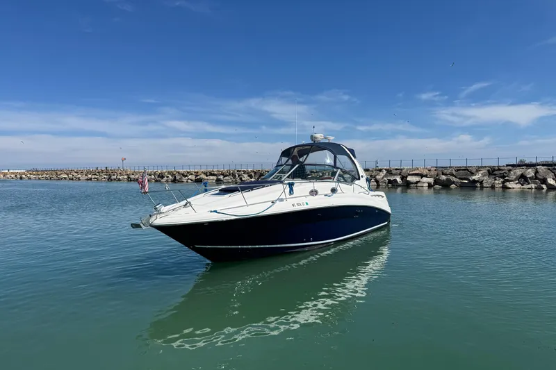 Slide: The Image of 2004 Sea Ray Sundancer 320 yacht on calm water, clear sky background. - 2