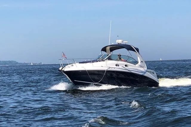 Slide: The Image of 2004 Sea Ray Sundancer 320 cruising on open water under clear blue skies. - 21