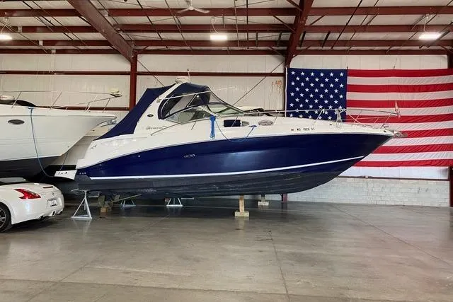 Slide: The Image of 2004 Sea Ray Sundancer 320 boat in indoor storage, American flag backdrop. - 23