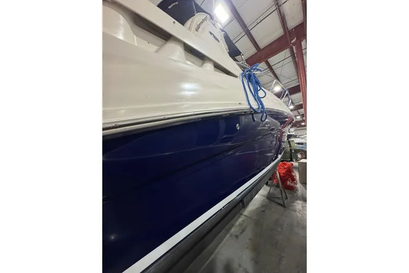 Slide: The Image of 2004 Sea Ray Sundancer 320 boat in storage, featuring a sleek blue and white hull. - 29