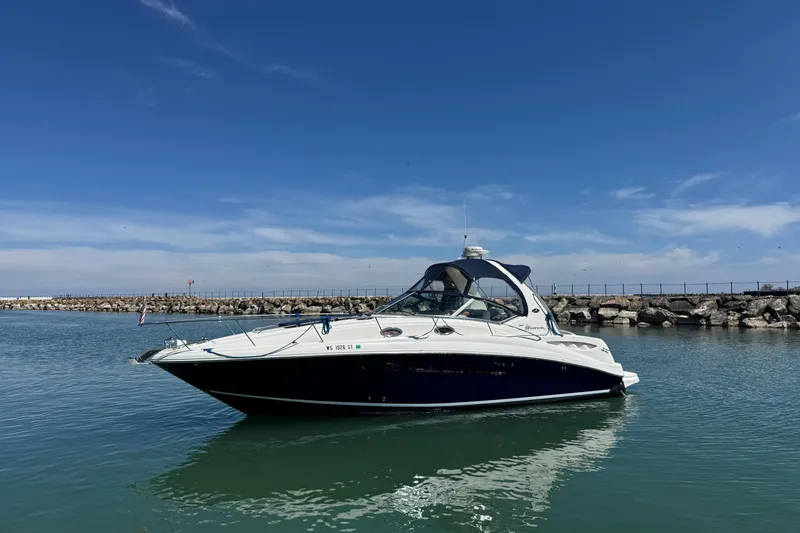 Slide: The Image of 2004 Sea Ray Sundancer 320 yacht on calm water under clear blue sky. - 4