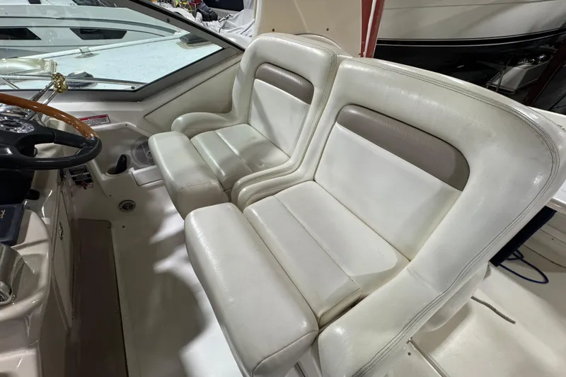 Slide: The Image of 2004 Sea Ray Sundancer 320 cockpit with dual white leather seats and steering wheel. - 41