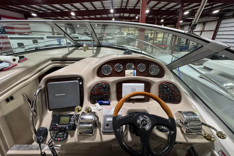 Slide: The Image of 2004 Sea Ray Sundancer 320 helm with navigation equipment and steering wheel in a boat showroom. - 42