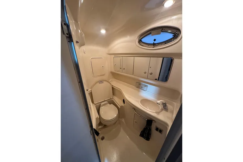 Slide: The Image of 2004 Sea Ray Sundancer 320 bathroom with toilet, sink, mirror, and storage cabinets. - 47
