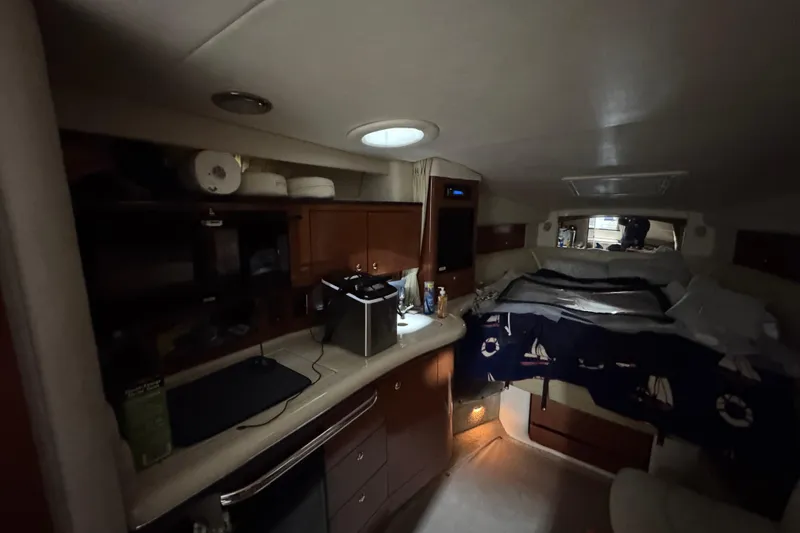 Slide: The Image of Interior cabin of a 2004 Sea Ray Sundancer 320 yacht, featuring a cozy bed and kitchenette. - 48