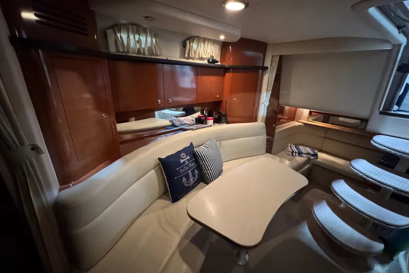 Slide: The Image of 2004 Sea Ray Sundancer 320 cabin interior with seating, table, and wooden cabinetry. - 53