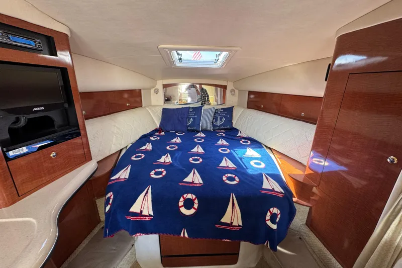 Slide: The Image of Interior cabin of 2004 Sea Ray Sundancer 320 with nautical-themed bedding. - 56