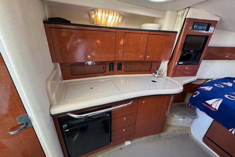 Slide: The Image of 2004 Sea Ray Sundancer 320 cabin interior with kitchenette, sink, and storage cabinets. - 59
