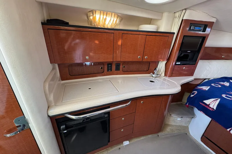 Slide: The Image of Interior of a 2004 Sea Ray Sundancer 320 yacht, featuring a compact kitchenette. - 60