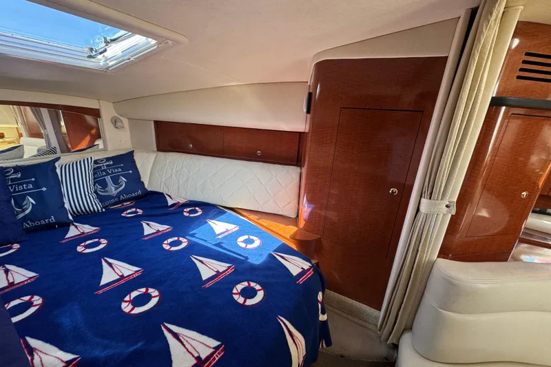 Slide: The Image of Interior of 2004 Sea Ray Sundancer 320 with nautical-themed bedding and wood paneling. - 61