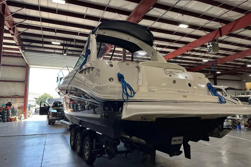 Slide: The Image of 2004 Sea Ray Sundancer 320 yacht in a warehouse, rear view with blue ropes. - 64