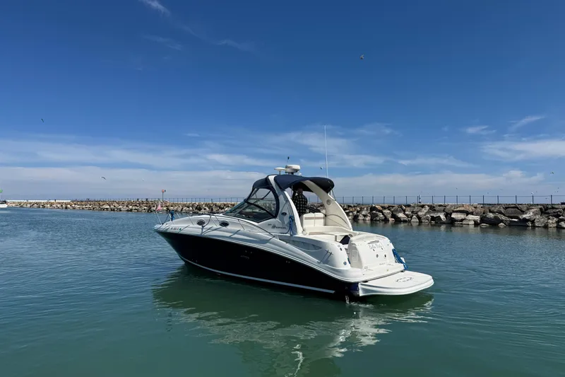 Slide: The Image of 2004 Sea Ray Sundancer 320 yacht on calm water under clear blue sky. - 7