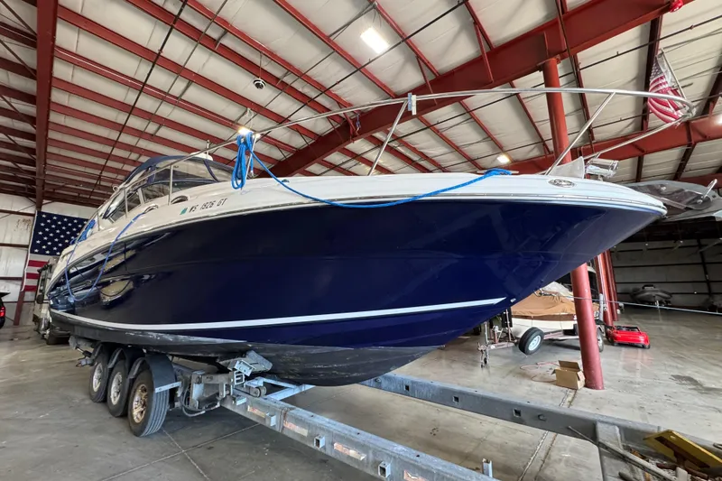 Slide: The Image of 2004 Sea Ray Sundancer 320 yacht on trailer in a spacious indoor storage facility. - 73