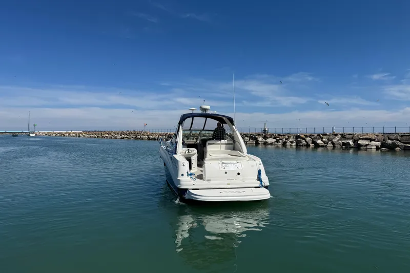 Slide: The Image of 2004 Sea Ray Sundancer 320 yacht on calm water under clear blue sky. - 9