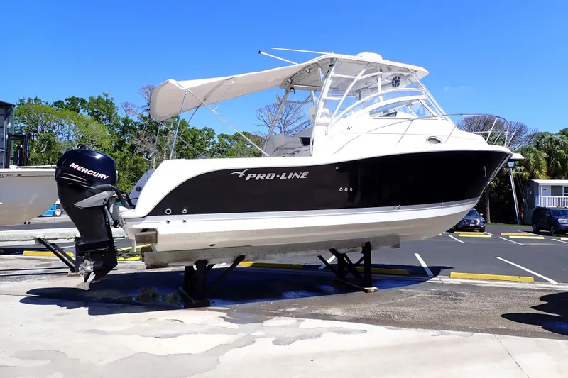 The Image of 2014 Pro-Line 32 Express boat with Mercury engine on display in a parking lot. - 1