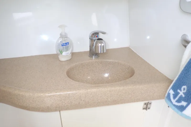 Slide: The Image of 2014 Pro-Line 32 Express boat bathroom sink with soap dispenser and nautical towel. - 103