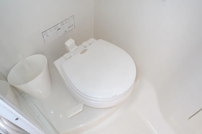 Slide: The Image of 2014 Pro-Line 32 Express boat bathroom with white toilet and brush holder. - 104