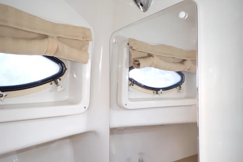 Slide: The Image of 2014 Pro-Line 32 Express cabin interior with portholes and beige curtains. - 106