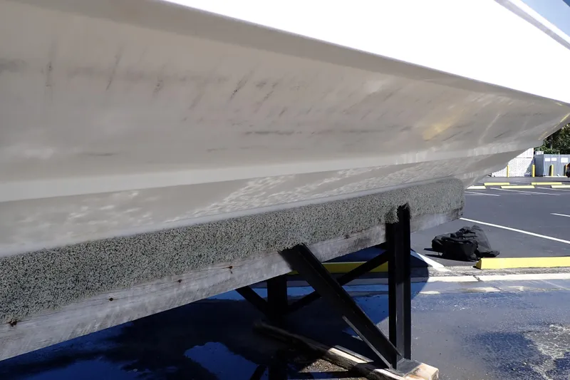 Slide: The Image of 2014 Pro-Line 32 Express boat hull on a trailer in a parking lot. - 123