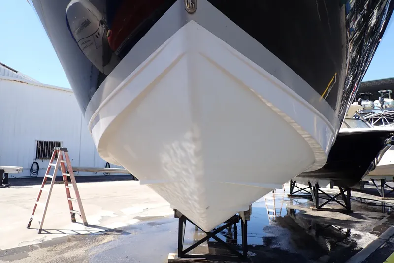 Slide: The Image of 2014 Pro-Line 32 Express boat hull on dry dock, with ladder nearby. - 125