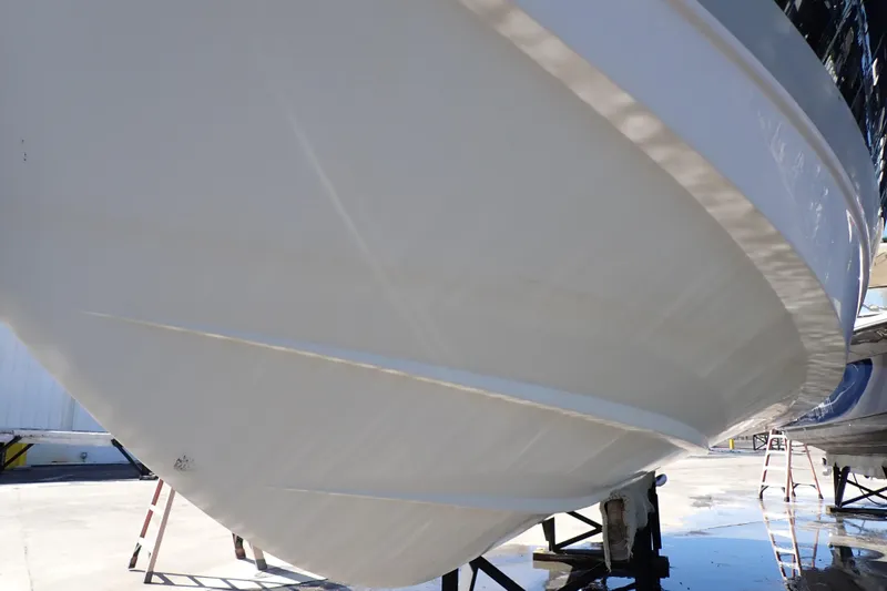 Slide: The Image of 2014 Pro-Line 32 Express boat hull on dry dock, showcasing sleek design. - 127