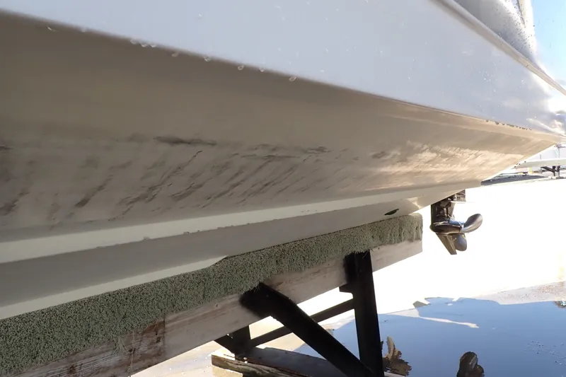 Slide: The Image of 2014 Pro-Line 32 Express boat hull on dry dock, showing underside and propeller. - 129