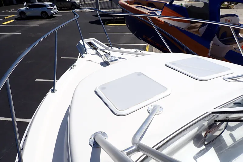 Slide: The Image of 2014 Pro-Line 32 Express boat deck with hatches and railing in a parking lot. - 16