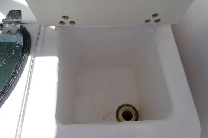 Slide: The Image of Storage compartment on a 2014 Pro-Line 32 Express boat, featuring a drain hole. - 31