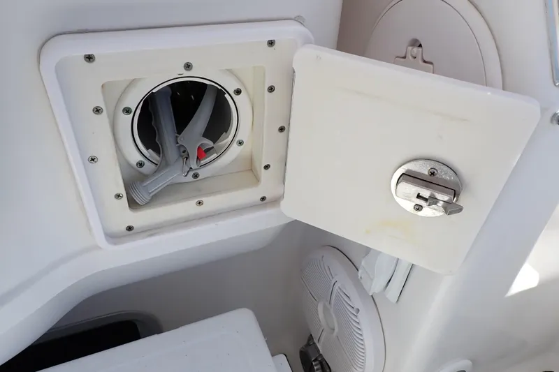 Slide: The Image of 2014 Pro-Line 32 Express boat compartment with open hatch and visible hose. - 32