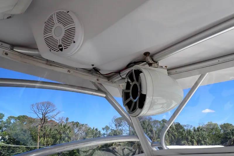 Slide: The Image of 2014 Pro-Line 32 Express boat speakers and canopy, with clear blue sky background. - 41