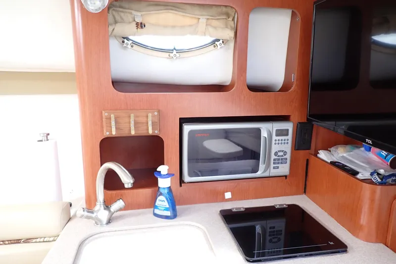 Slide: The Image of 2014 Pro-Line 32 Express boat kitchen with microwave, sink, and stove. - 83