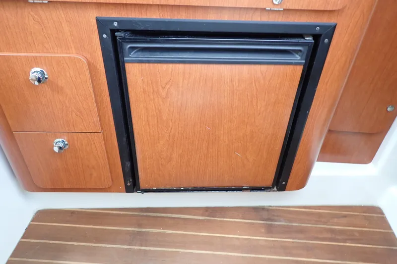 Slide: The Image of Wooden cabinetry and mini fridge in 2014 Pro-Line 32 Express boat interior. - 87