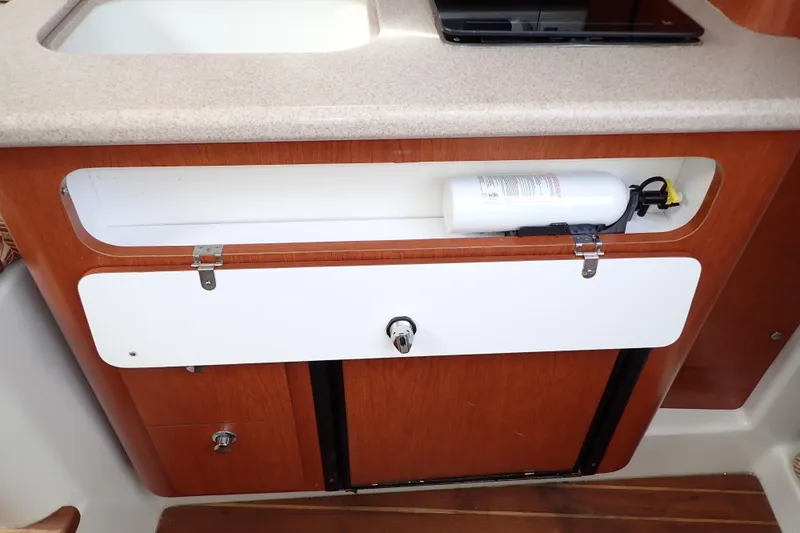 Slide: The Image of 2014 Pro-Line 32 Express boat interior with fire extinguisher in wooden cabinet. - 89