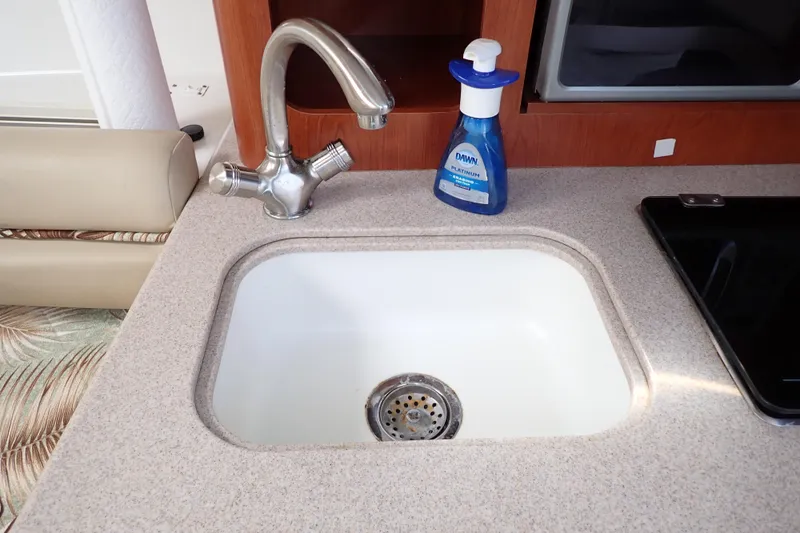 Slide: The Image of Kitchen sink area in 2014 Pro-Line 32 Express boat with faucet and soap bottle. - 90