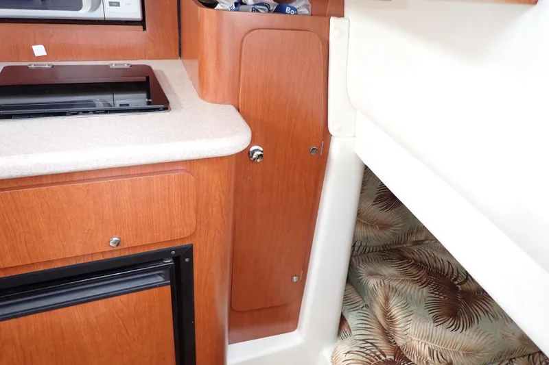 Slide: The Image of 2014 Pro-Line 32 Express cabin interior with wood cabinetry and compact kitchen area. - 92