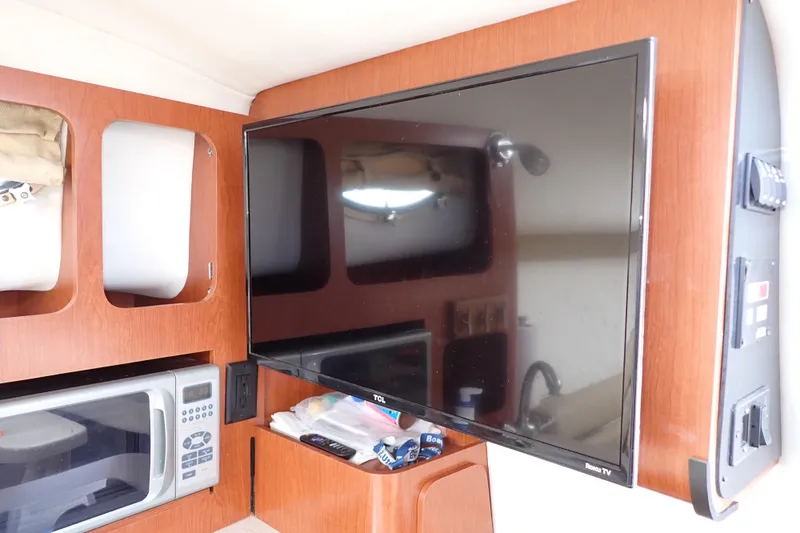 Slide: The Image of Interior of 2014 Pro-Line 32 Express with TV, microwave, and wooden cabinetry. - 94
