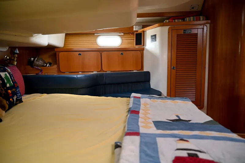 Slide: The Image of Cozy cabin interior of a 2002 Catalina 400 MkII sailboat with quilted bedding. - 12
