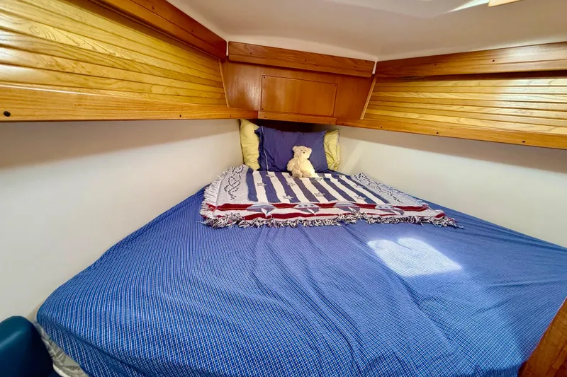 Slide: The Image of Cozy cabin bed in 2002 Catalina 400 MkII sailboat with wooden accents and plush decor. - 33
