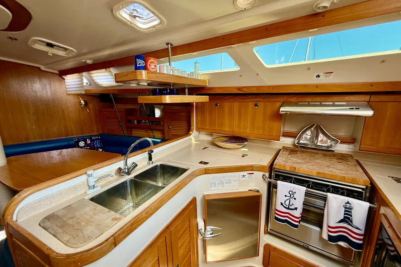 Slide: The Image of Interior of a 2002 Catalina 400 MkII sailboat kitchen with wood cabinetry and nautical decor. - 35