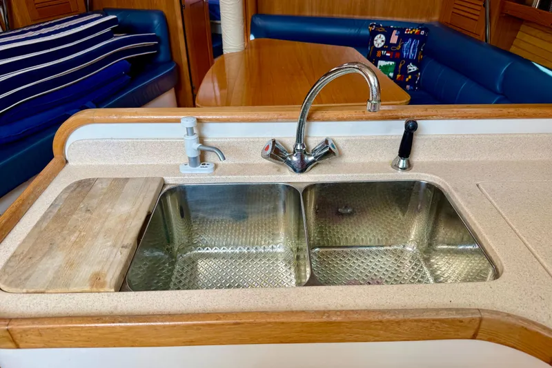 Slide: The Image of Kitchen sink area in a 2002 Catalina 400 MkII yacht, featuring dual basins and wooden accents. - 36