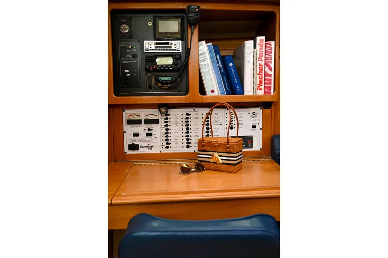 Slide: The Image of Navigation station of a 2002 Catalina 400 MkII yacht with control panels and manuals. - 9