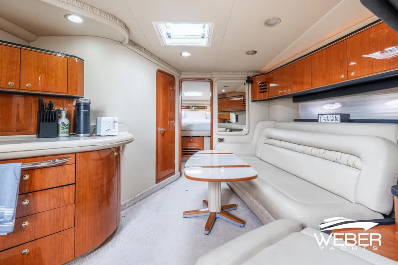 Slide: The Image of Luxurious interior of 2000 Sea Ray Sundancer 460 yacht with elegant wood cabinetry and plush seating. - 26