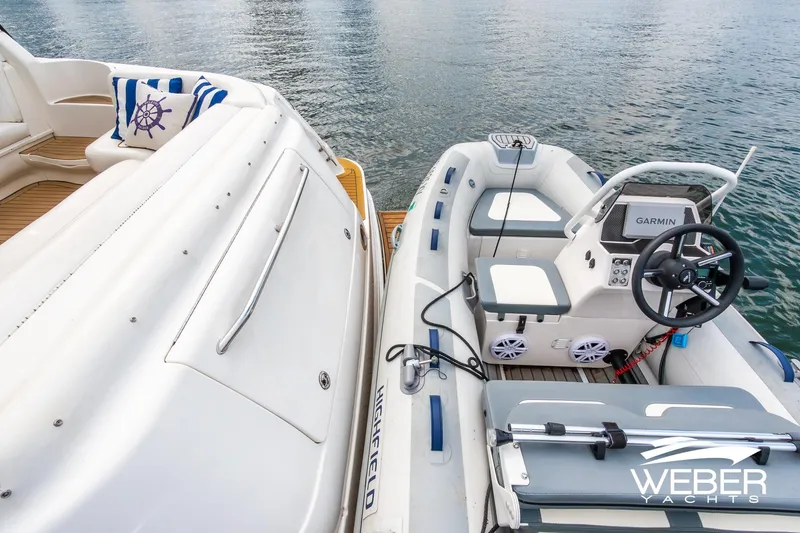 Slide: The Image of Sea Ray Sundancer 460 yacht with inflatable boat, docked on calm water. - 43