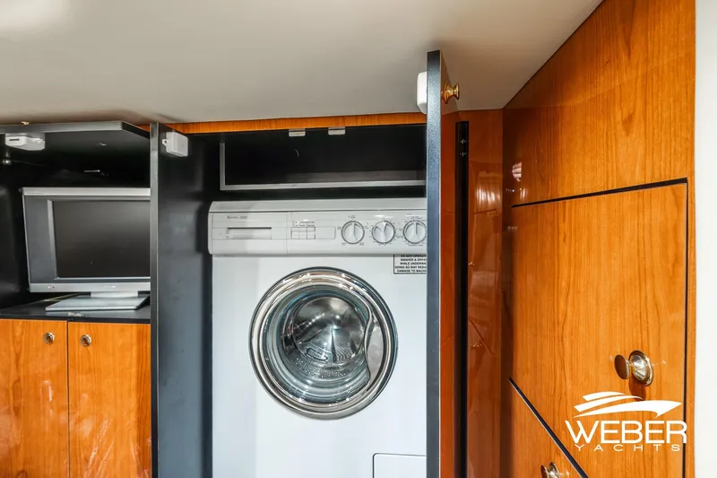 Slide: The Image of Laundry area inside 2000 Sea Ray Sundancer 460 yacht with wooden cabinetry and TV. - 20